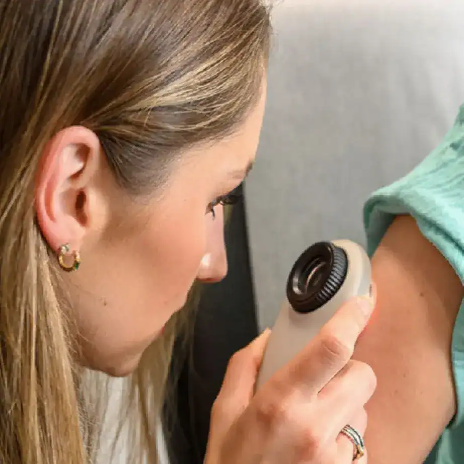 Surgical Dermatology Group provider looks at a patient's skin