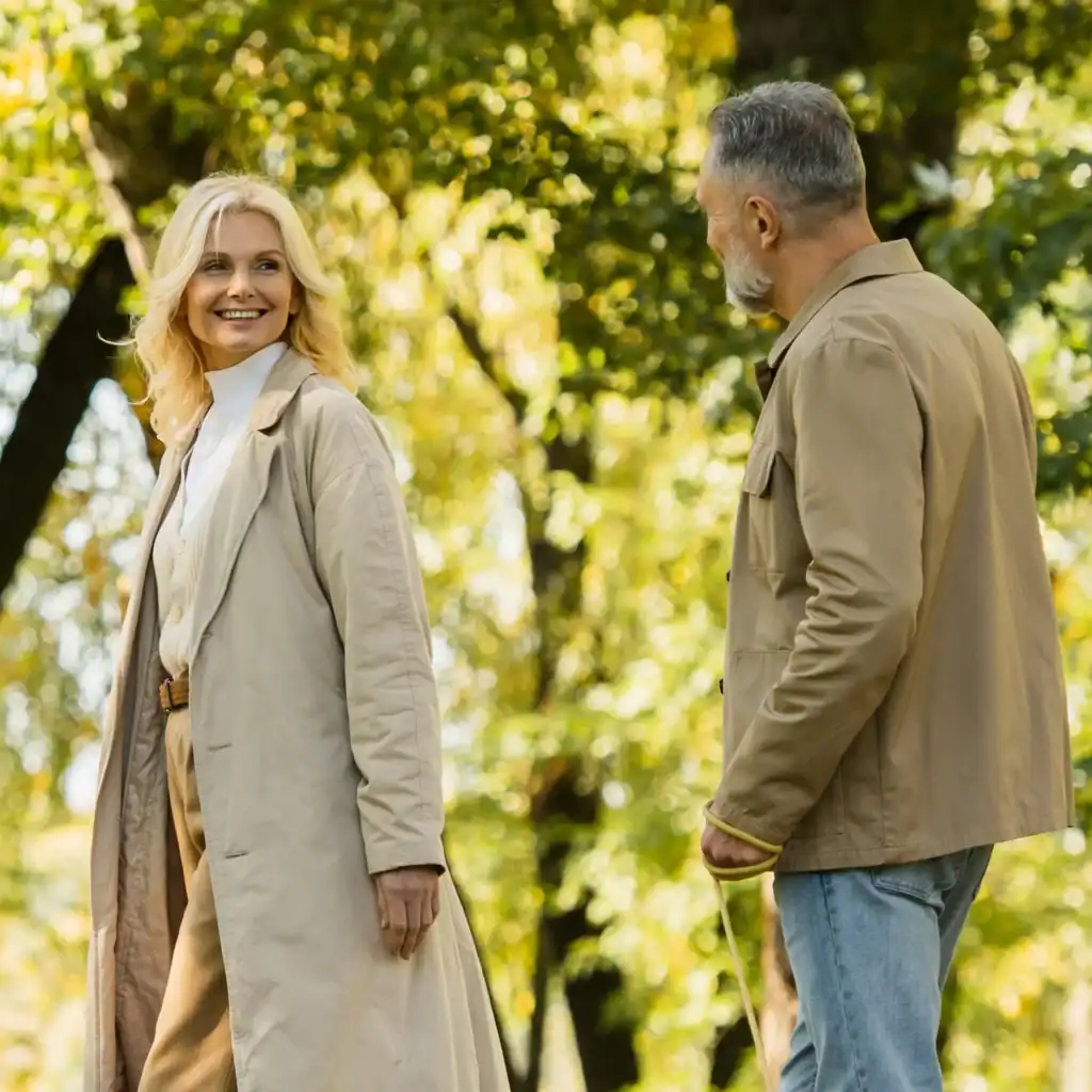 Attractive older couple walk in the woods