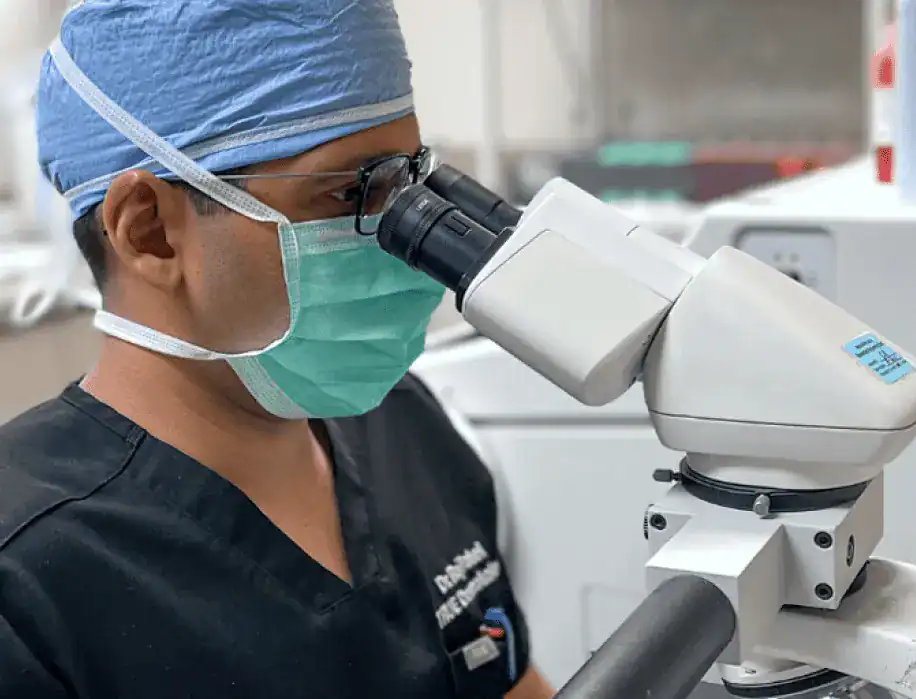 Dr. Raj Patel studies a dermatology slide under a microscope